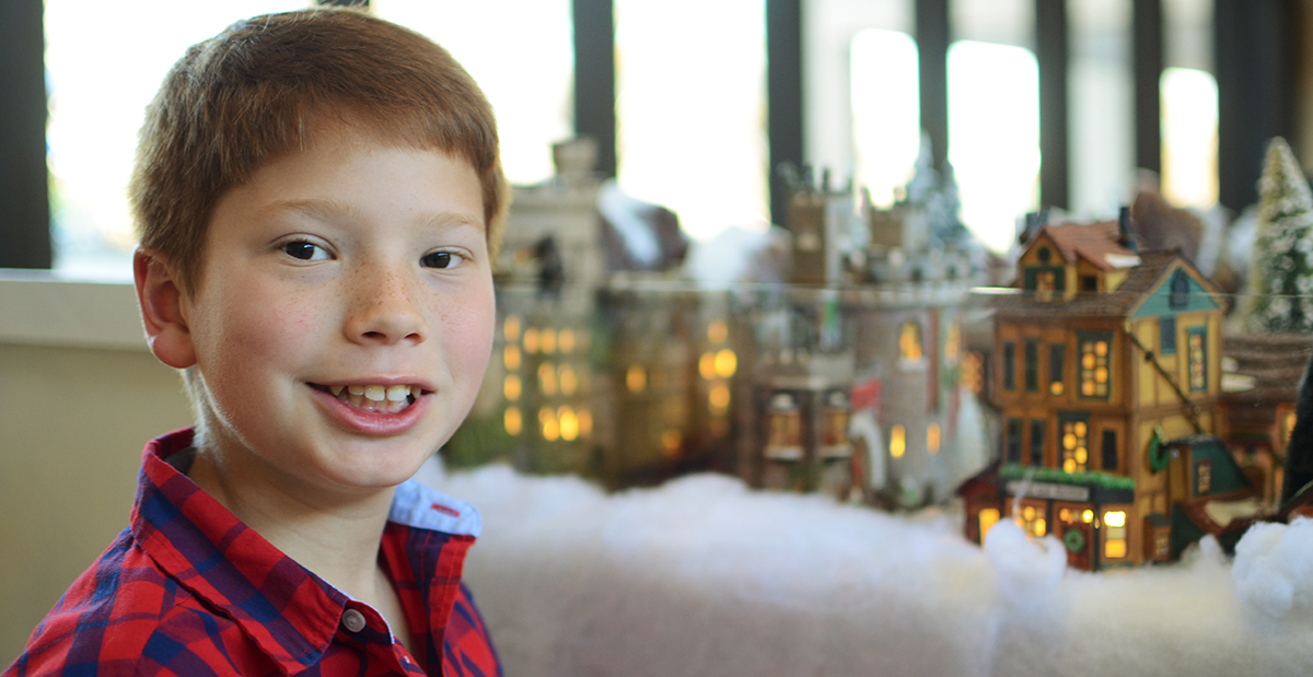 Micah poses by our Christmas Village