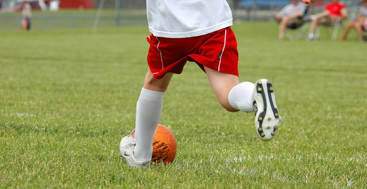 Child stretches on a soccer field