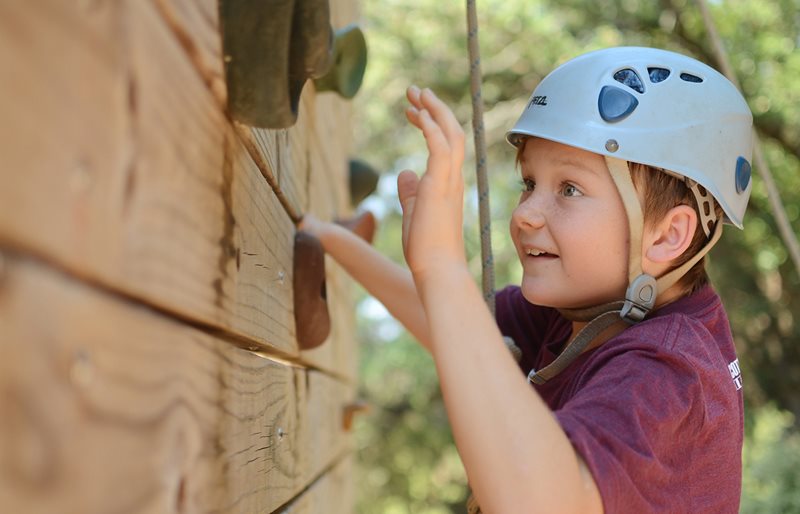 Young boy rock climbing at Texas Scottish Rite Hospital for Children recreational camp