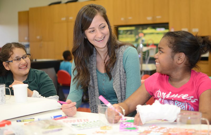 Child Life Specialist and patients smiling while coloring at Texas Scottish Rite Hospital for Children 