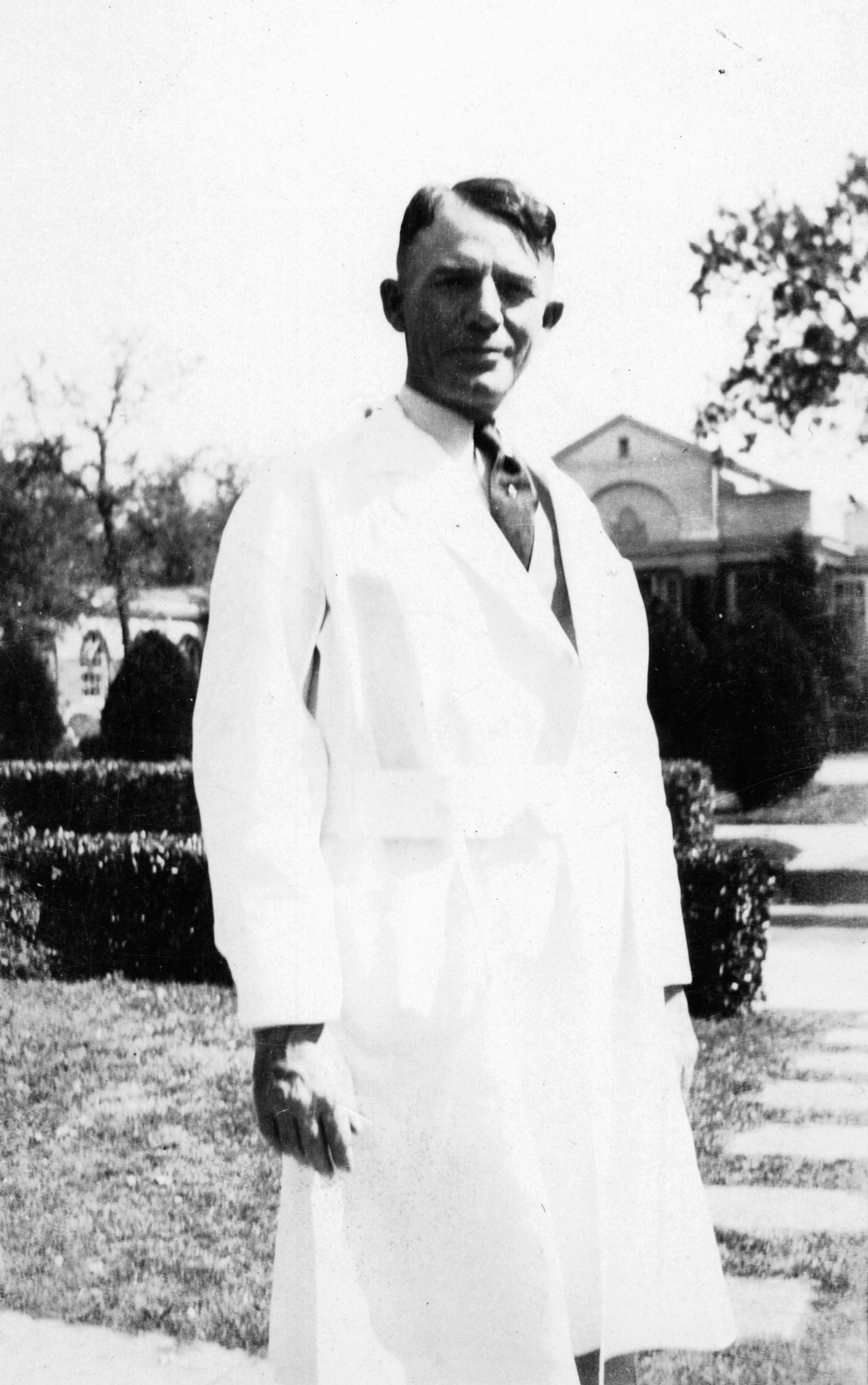 Dr. Carrell standing outside in white lab coat.