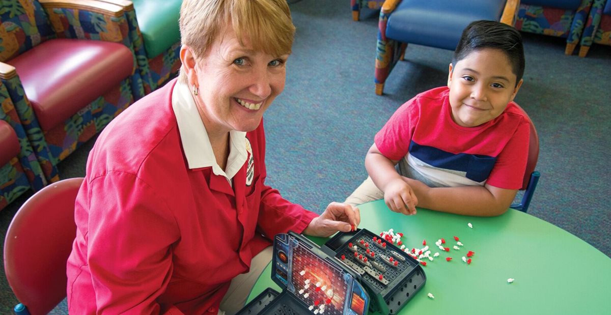 Texas Scottish Rite Hospital for Children volunteer plays with patient
