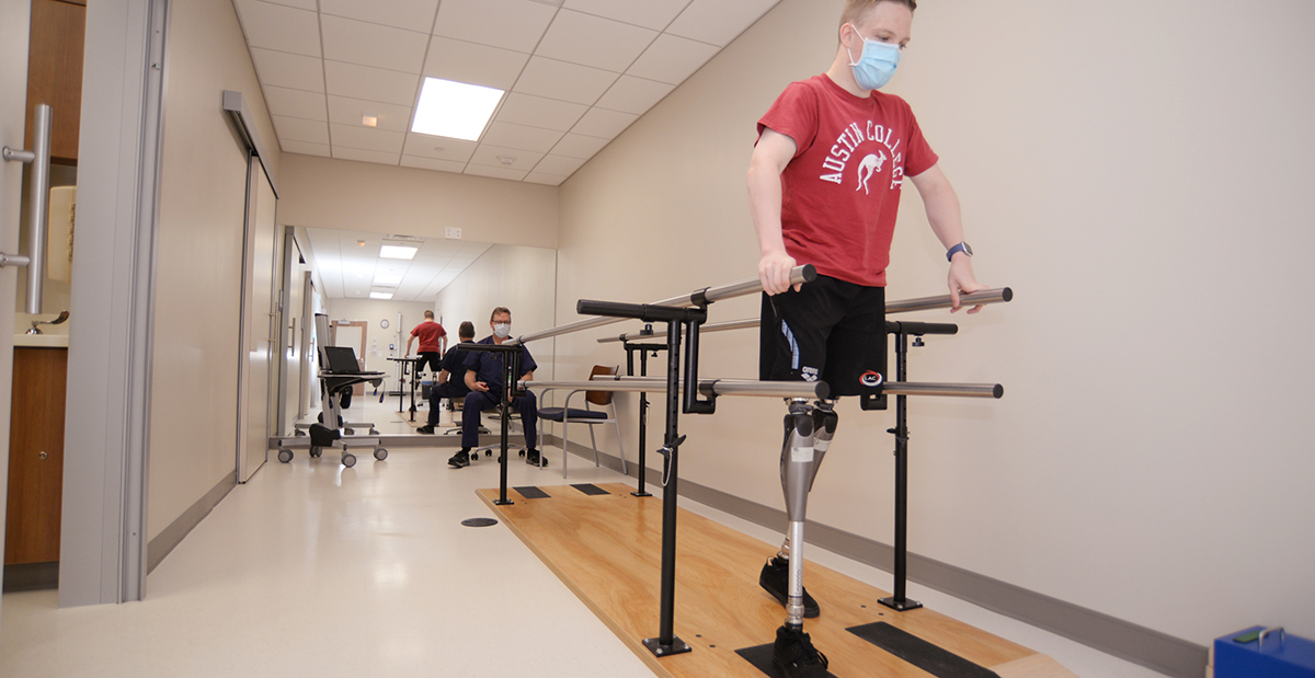 patient, Cody walking with his new prosthesis