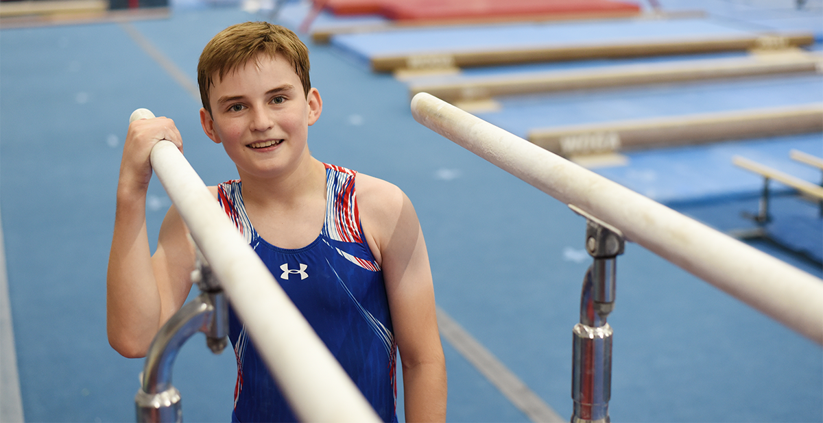 A young boy stands on bars