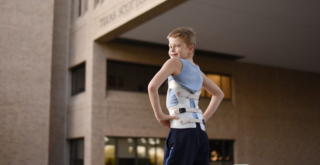 child in brace outside hospital