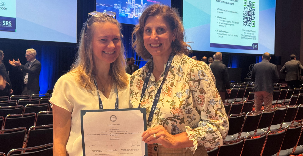 Amy L. McIntosh, M.D., and Karina Zapata, Ph.D., pose with their award from the Scoliosis Research Society.
