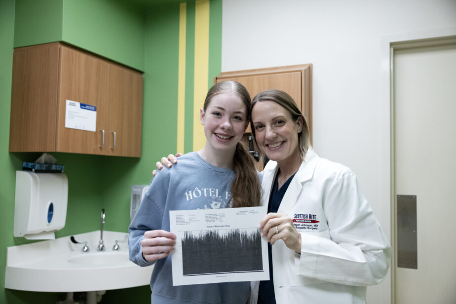Zakyah Cain and Dr. Haslet Johnson holding scoliosis condition reading graph.