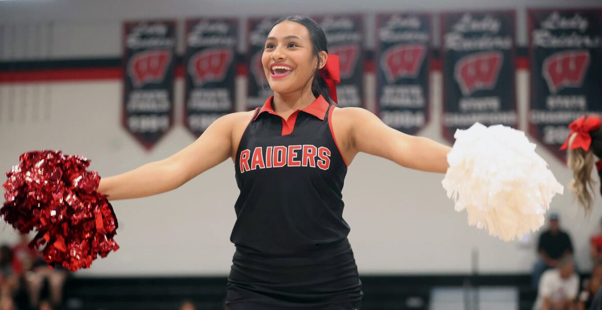 High school girl is cheerleading at school event.